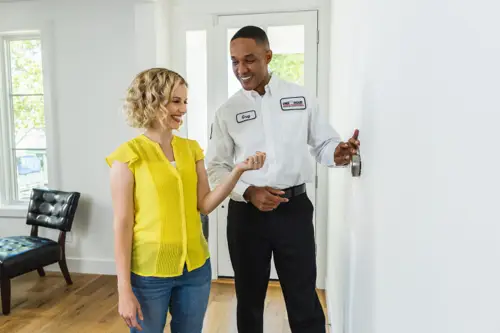 One Hour AC Tech, Greg, speaking with a Miami homeowner about her new Thermostat